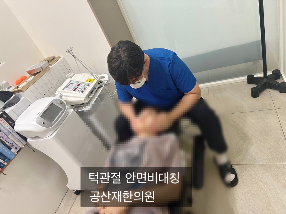 한의원이자 치료실에서 한의사가 환자의 얼굴을 치료하는 모습. 옆에는 의료 장비가 놓여 있다.